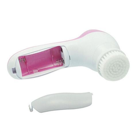 Compact pink and white electric facial cleanser with detachable soft brush head and battery compartment open for AA batteries installation