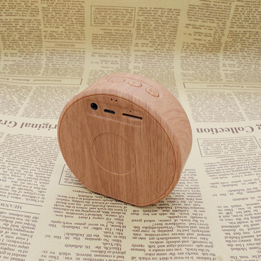 Back view of Mini Bluetooth Speaker Outdoor Portable showing AUX, TF card slot, and control buttons in a wood grain design.