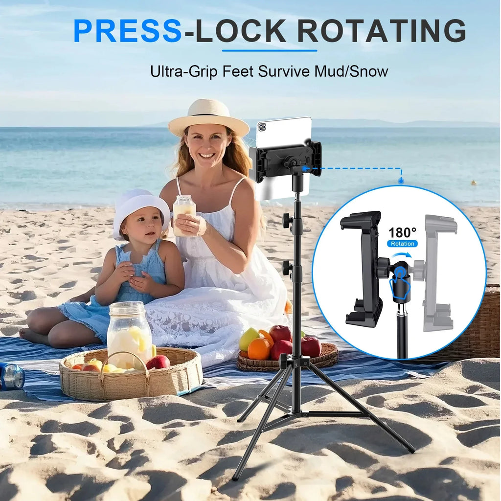Adjustable tripod floor tablet stand with rotating mount holding a tablet on a beach setting with mother and child in background