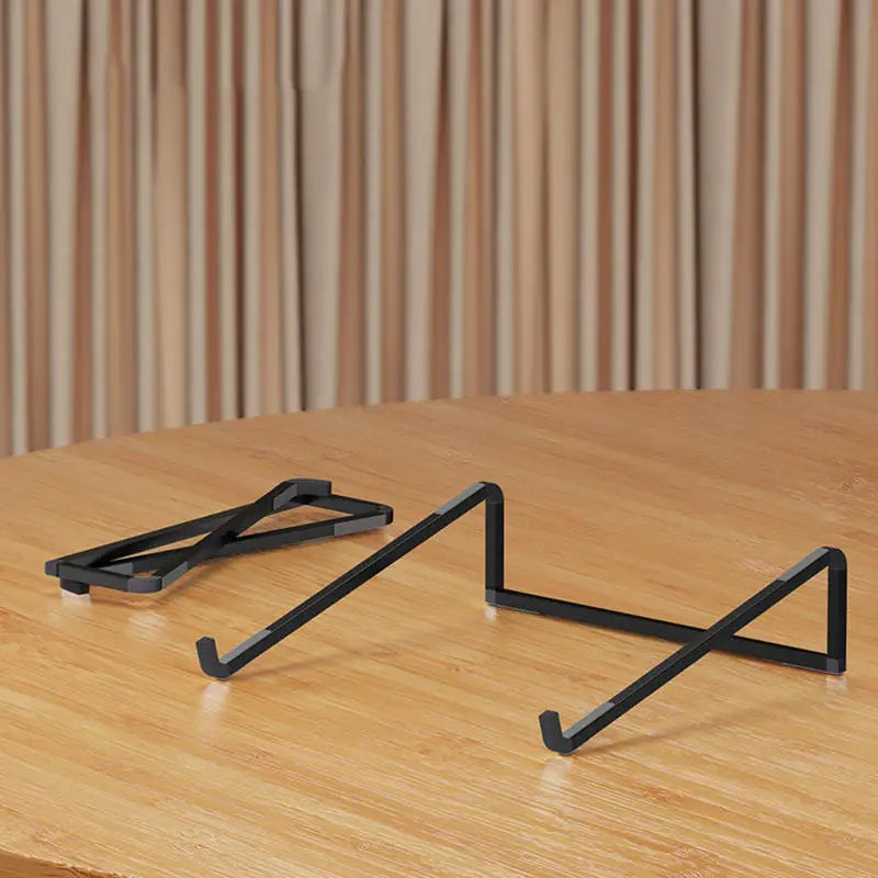 Foldable adjustable aluminum alloy laptop stand on wooden table with vertical striped background